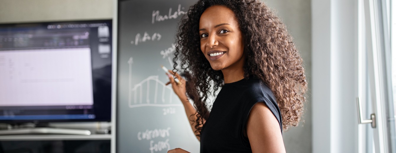 Young woman presents a graph on a blackboard