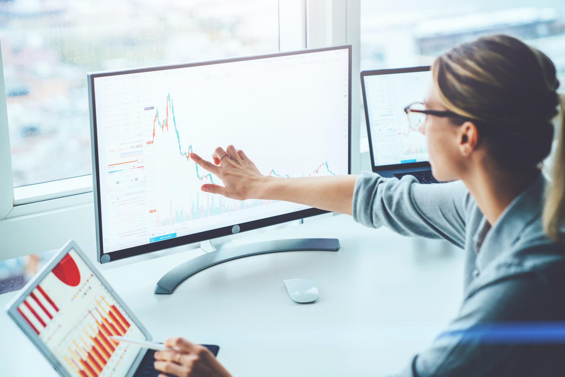 Young female employee working with complex graphs